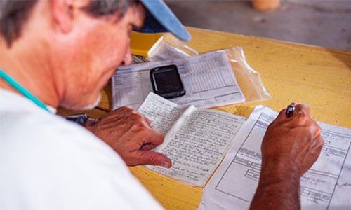 man filling out forms with a pen